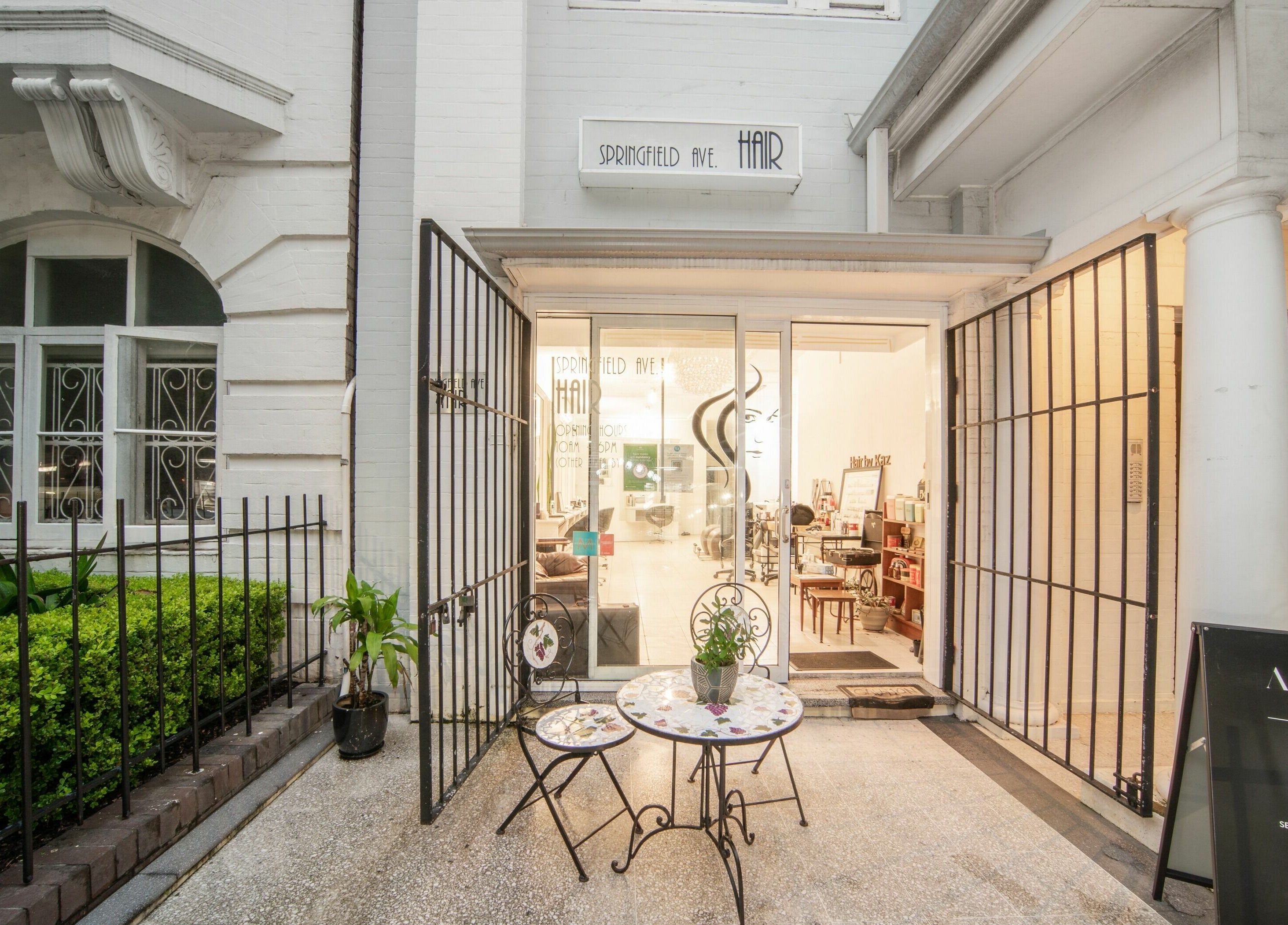 Amore Salon entrance in Potts Point, New South Wales, AU, showcasing elegant outdoor seating and inviting ambiance.