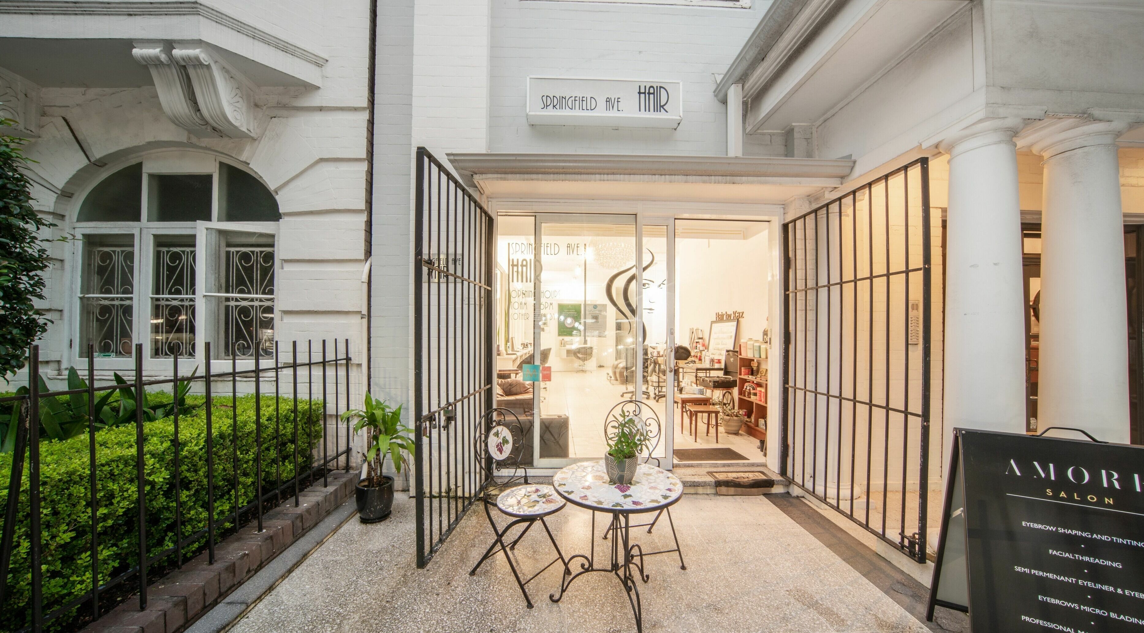 Amore Salon entrance in Potts Point, New South Wales, AU, showcasing elegant outdoor seating and inviting ambiance.