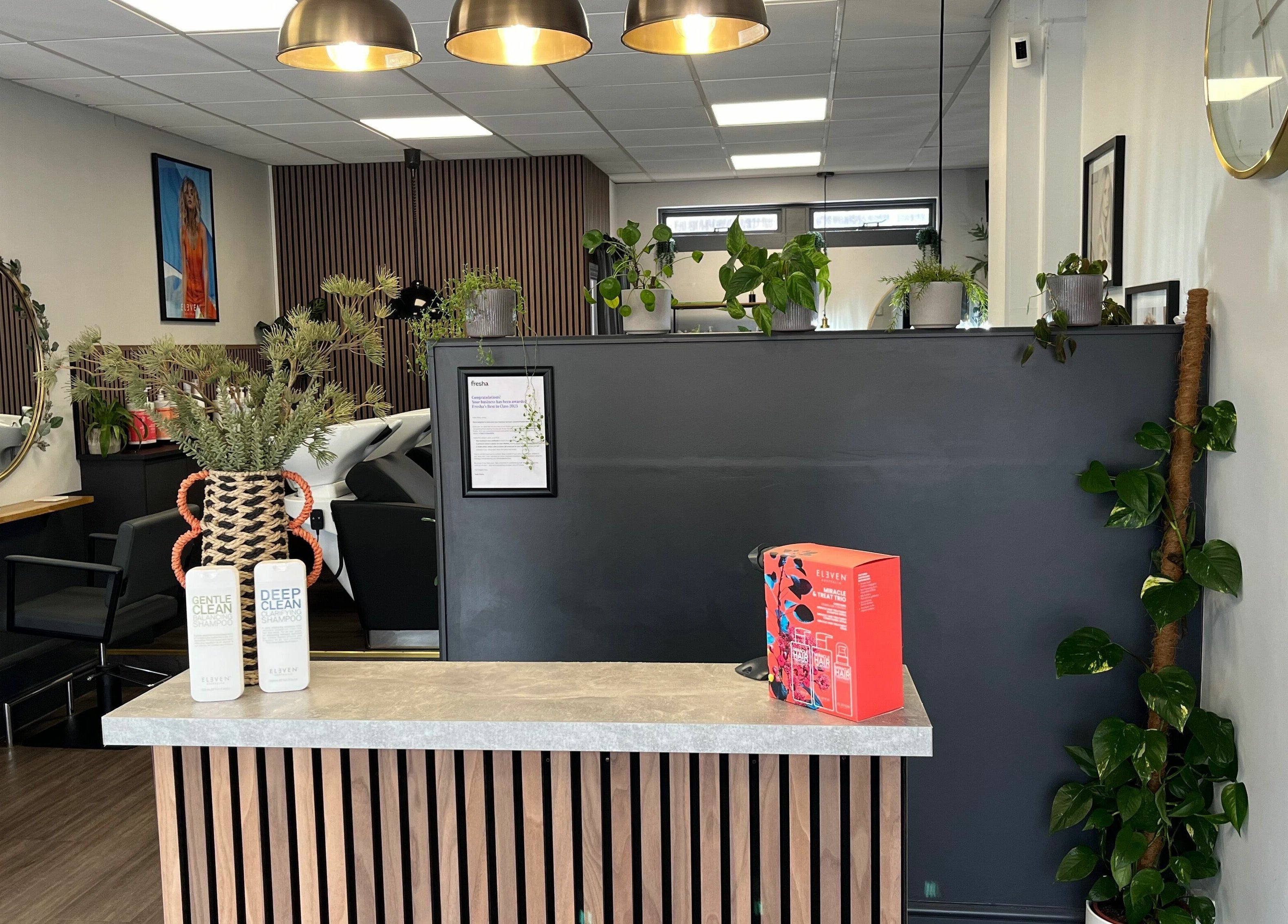 Modern salon reception at West One Hairdressing - West End, England, GB. Stylish decor with plants and products.