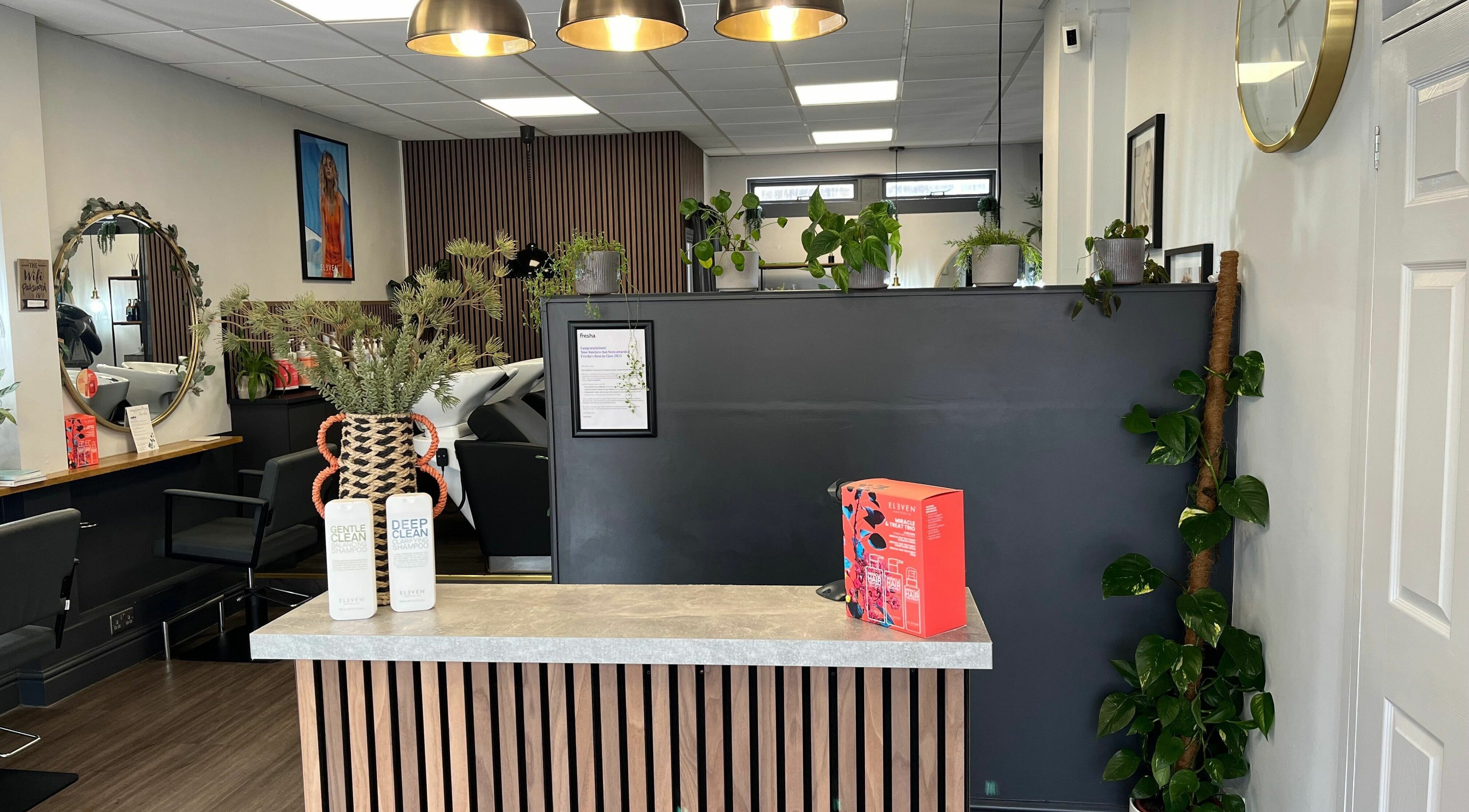 Modern salon reception at West One Hairdressing - West End, England, GB. Stylish decor with plants and products.