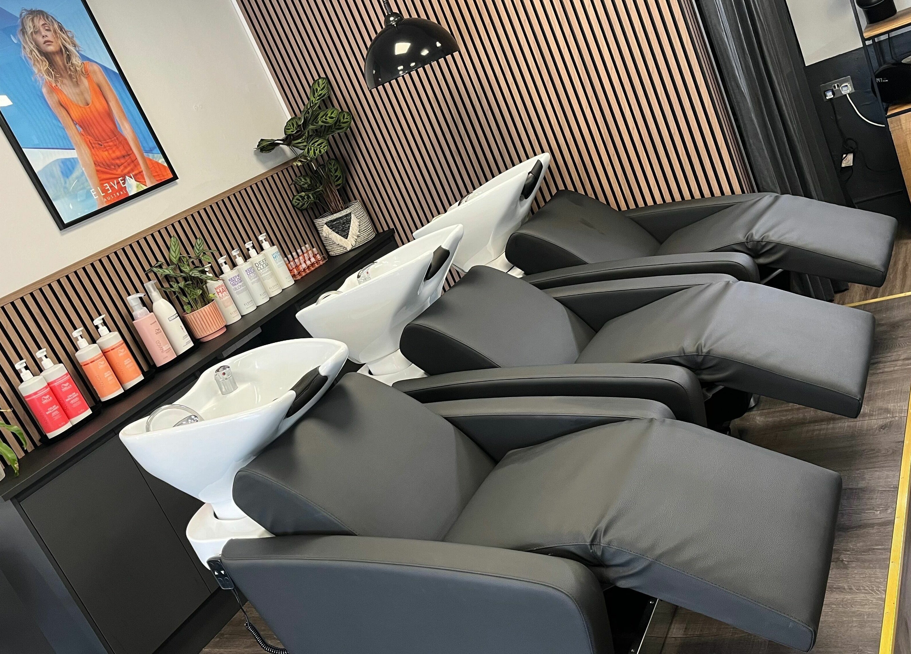 Luxurious salon setup at West One Hairdressing - West End, England, GB with sleek black washbasin chairs.