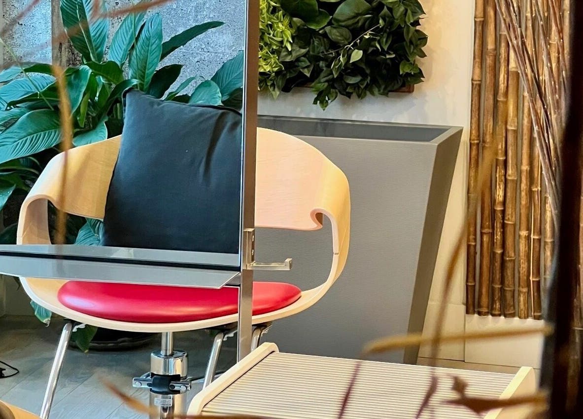 Modern salon chair at Yoko’s Haute Coiffure Ltd, North Vancouver, British Columbia, CA, with lush plants.