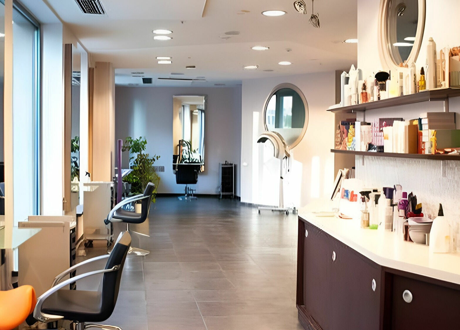Bright and modern salon interior of LE STUDIO in Rīga, LV, featuring styling chairs and hair care products.