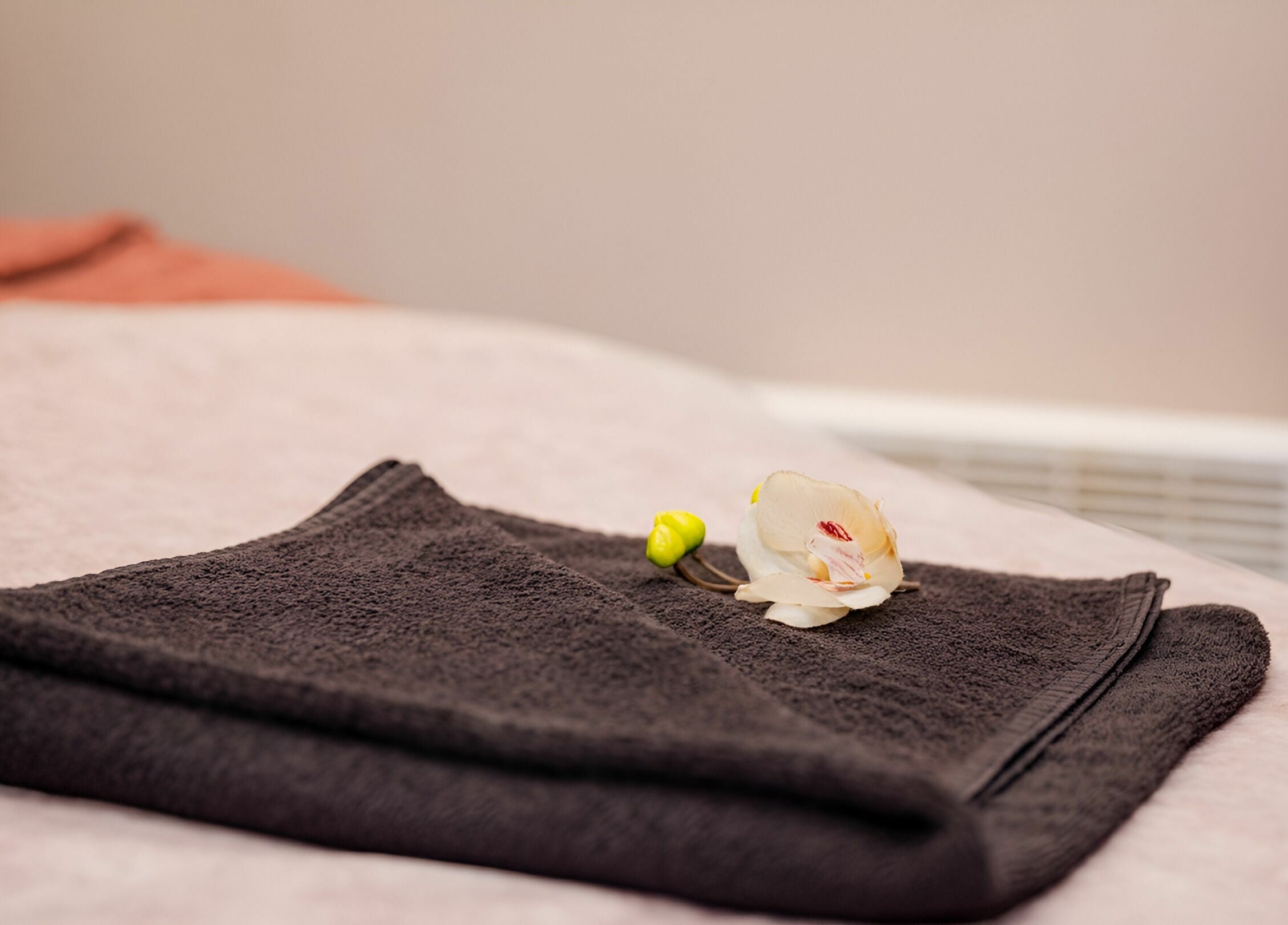 Luxurious spa towel with a flower at LE STUDIO, Rīga, LV. Perfect setting for relaxation and rejuvenation.