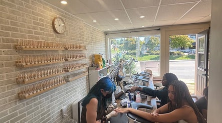 Clients receive manicures at La Crystal Studio in Ottawa, Ontario, CA. Elegant decor with brick walls and natural light.
