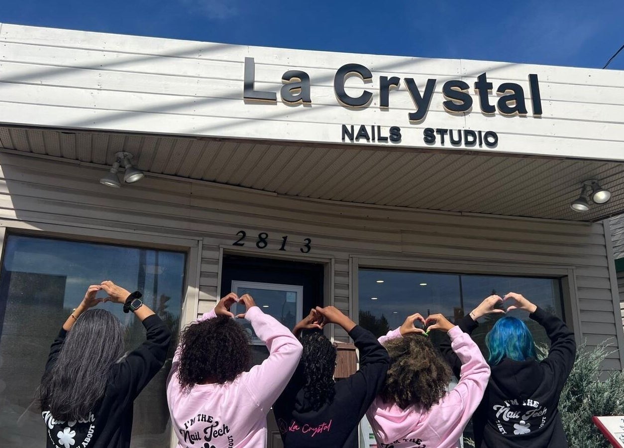 Team outside La Crystal Nail Studio, Ottawa, Ontario, CA showing heart gestures under the studio sign.