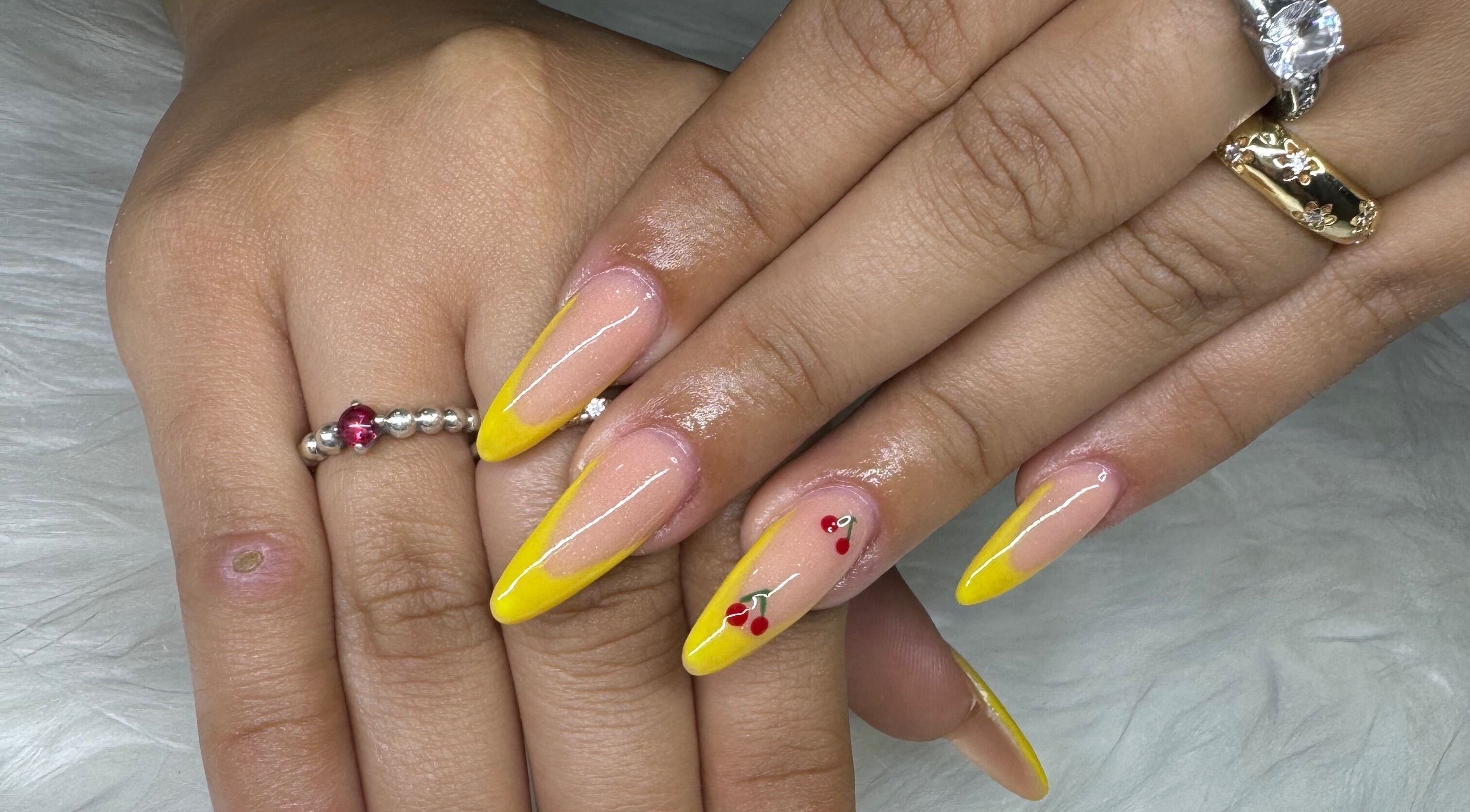 Yellow nails with cherry art at Blushin' Beauty, Dominguito, Willemstad, Curaçao, CW.