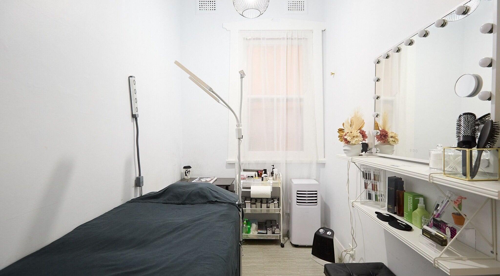 Cozy beauty room at Lashes By Ai in Surry Hills, New South Wales, AU, with a treatment bed and vanity mirror.