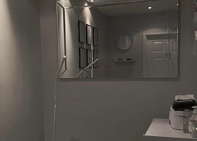Elegant treatment room at Hush Hush Beauty, Old Windsor, England, GB, featuring minimalist decor and a large mirror.