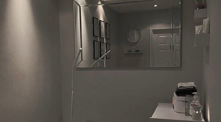 Elegant treatment room at Hush Hush Beauty, Old Windsor, England, GB, featuring minimalist decor and a large mirror.
