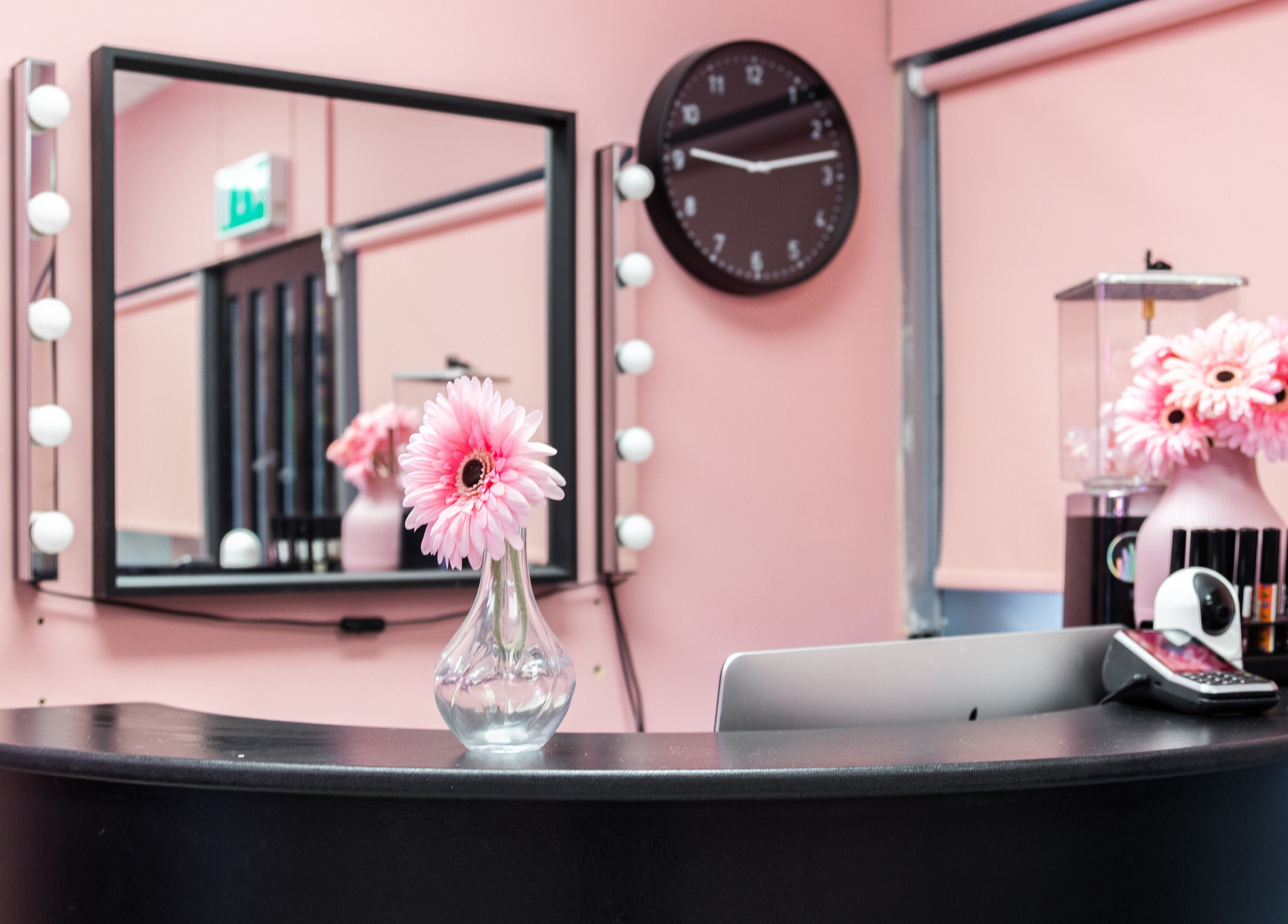 Chic reception desk at The Pink Room, Warrington, England with flowers and mirrors.