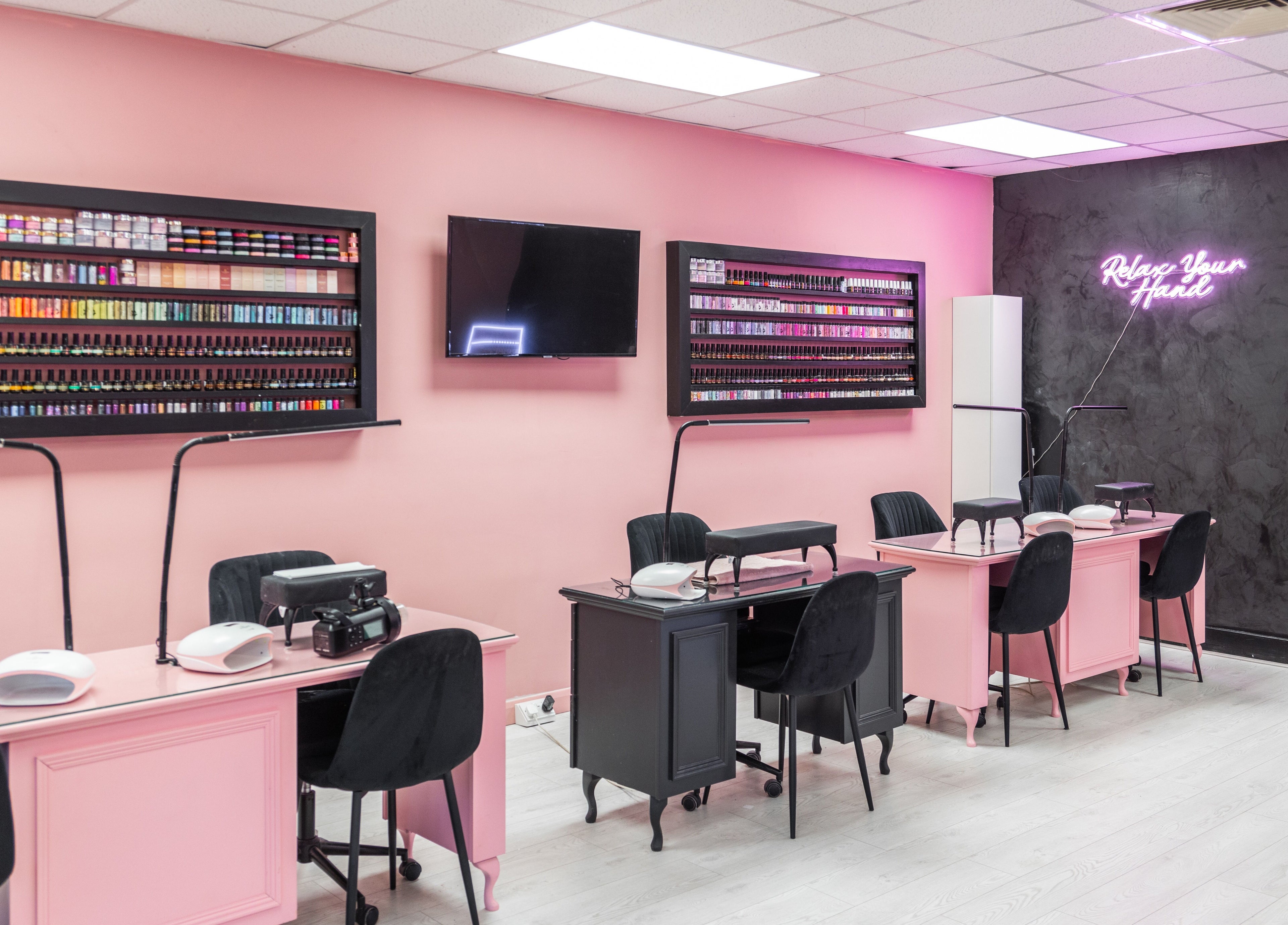 The Pink Room's stylish nail salon in Warrington, England, featuring elegant pink decor and nail stations.