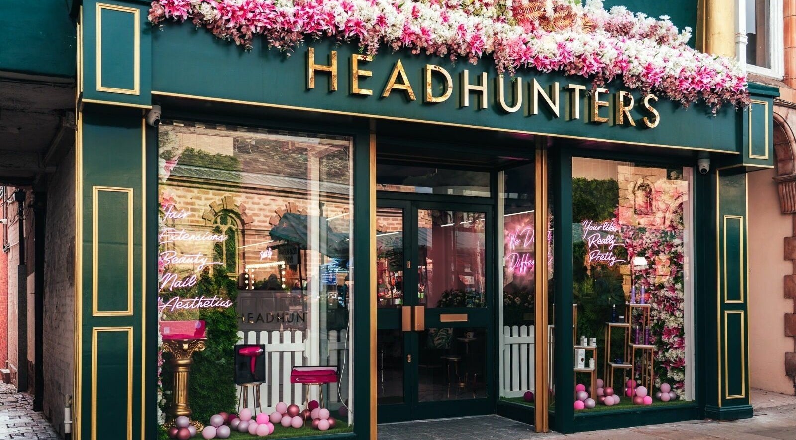 Head Hunters Salon Pontefract entrance adorned with vibrant pink flowers in Pontefract, England, GB.