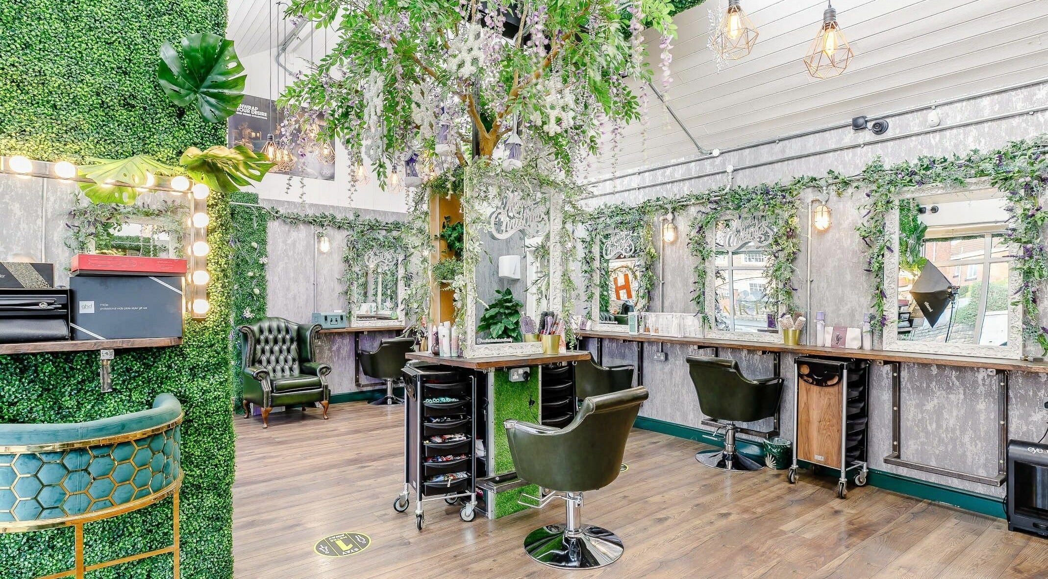 Stylish interior of HeadHunters Salon Dewsbury featuring greenery and salon stations in Dewsbury, England, GB.