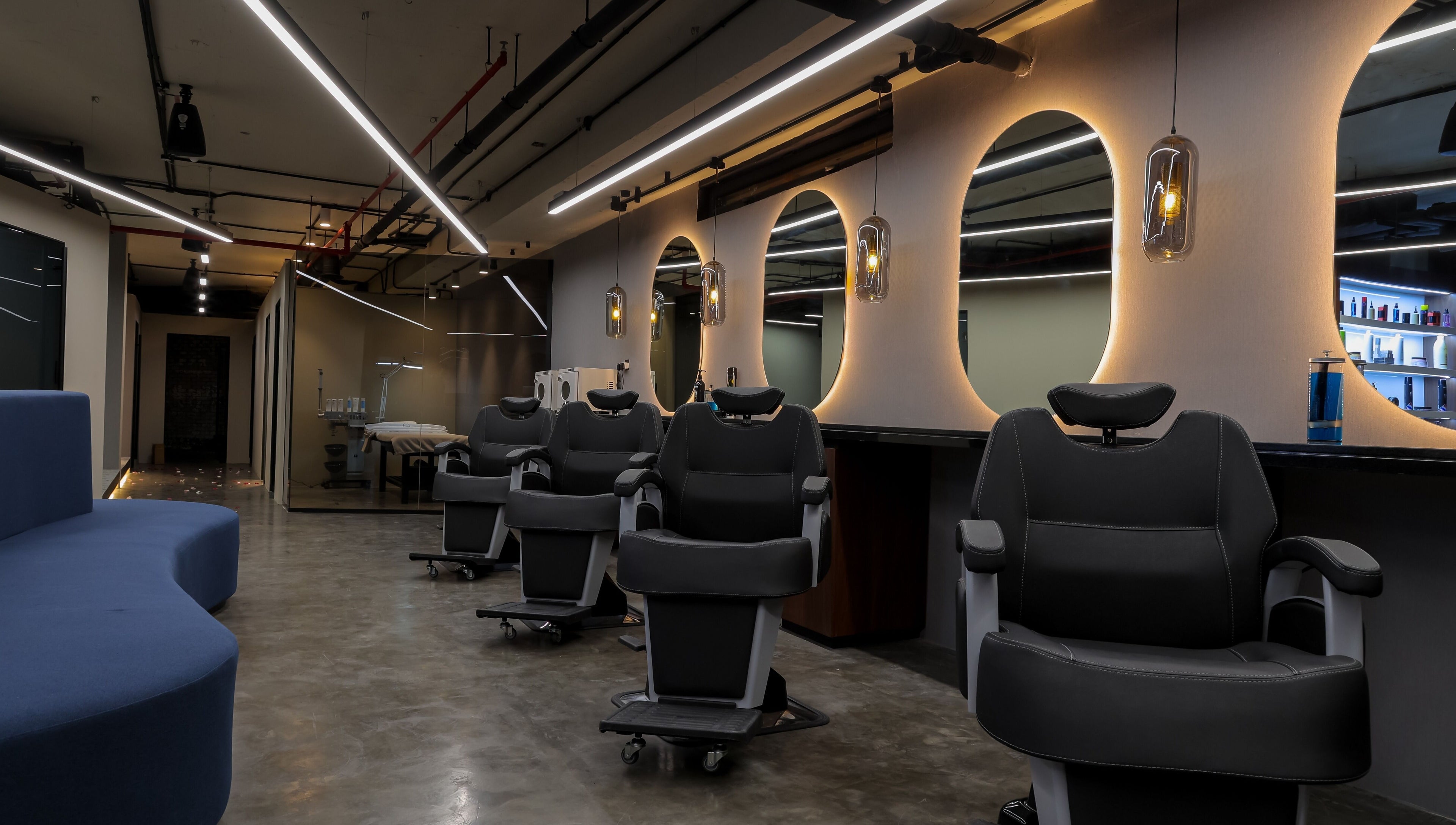 Modern salon interior at Hairpage in Saar, BH showcasing sleek chairs and ambient lighting.