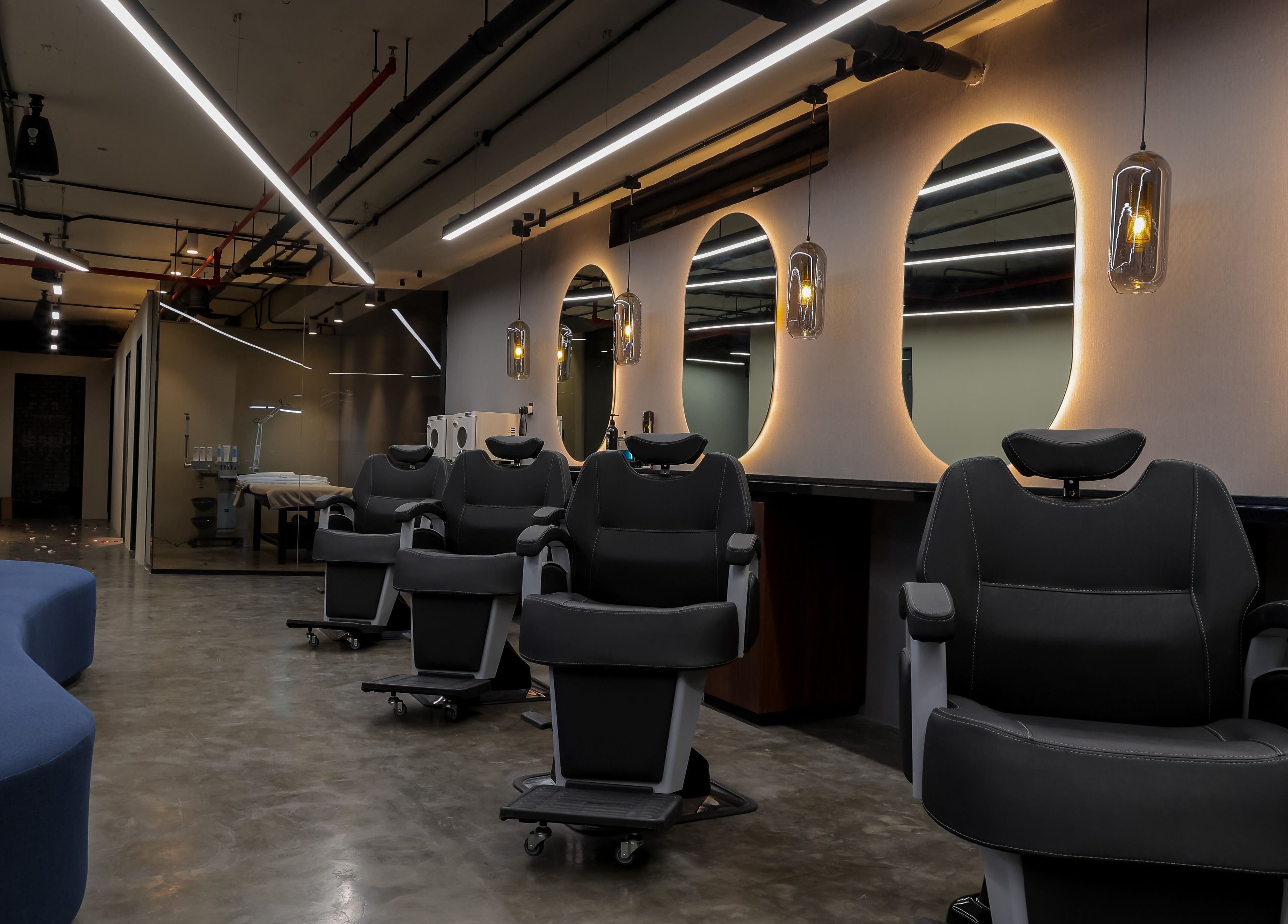 Modern salon interior at Hairpage in Saar, BH showcasing sleek chairs and ambient lighting.