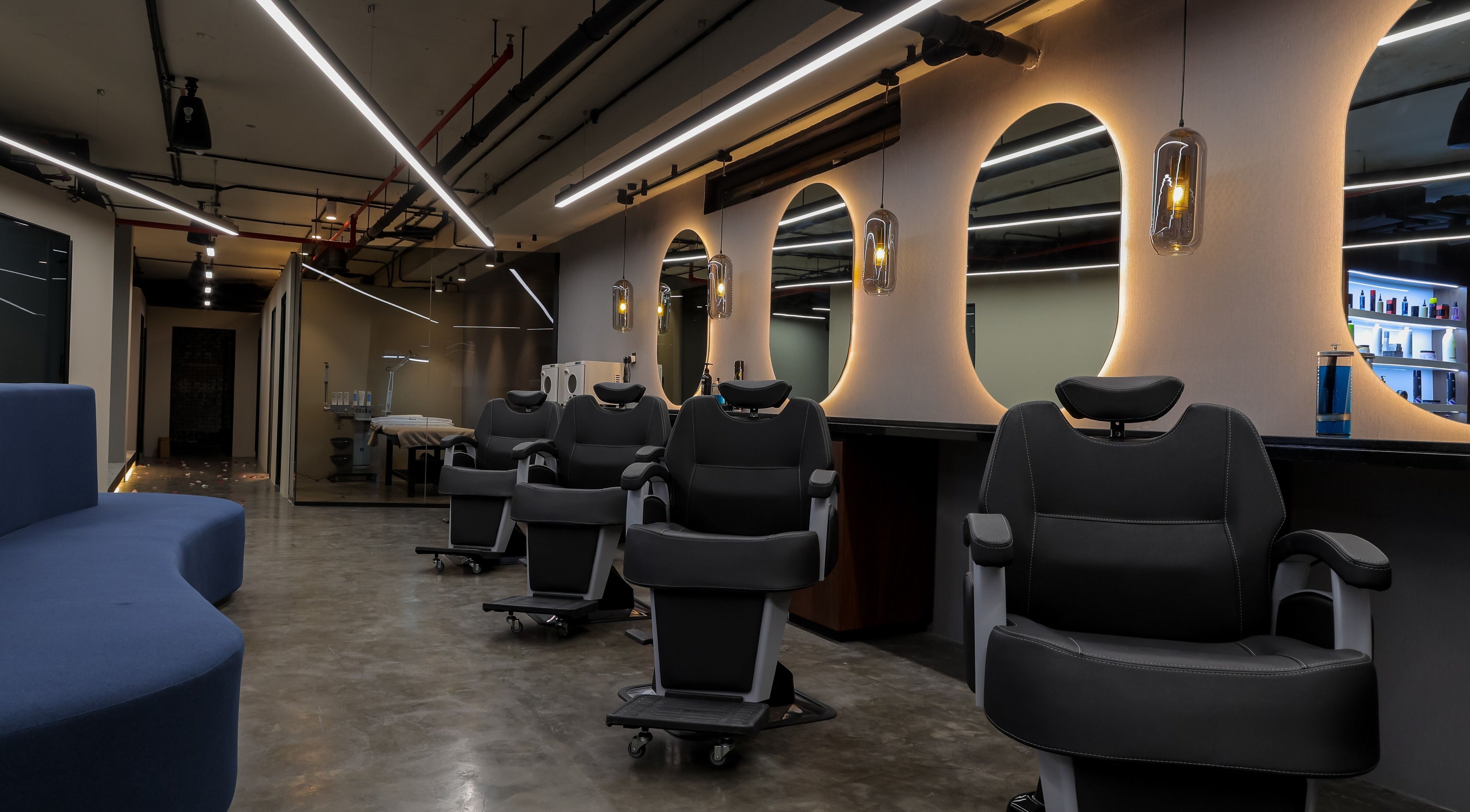 Modern salon interior at Hairpage in Saar, BH showcasing sleek chairs and ambient lighting.
