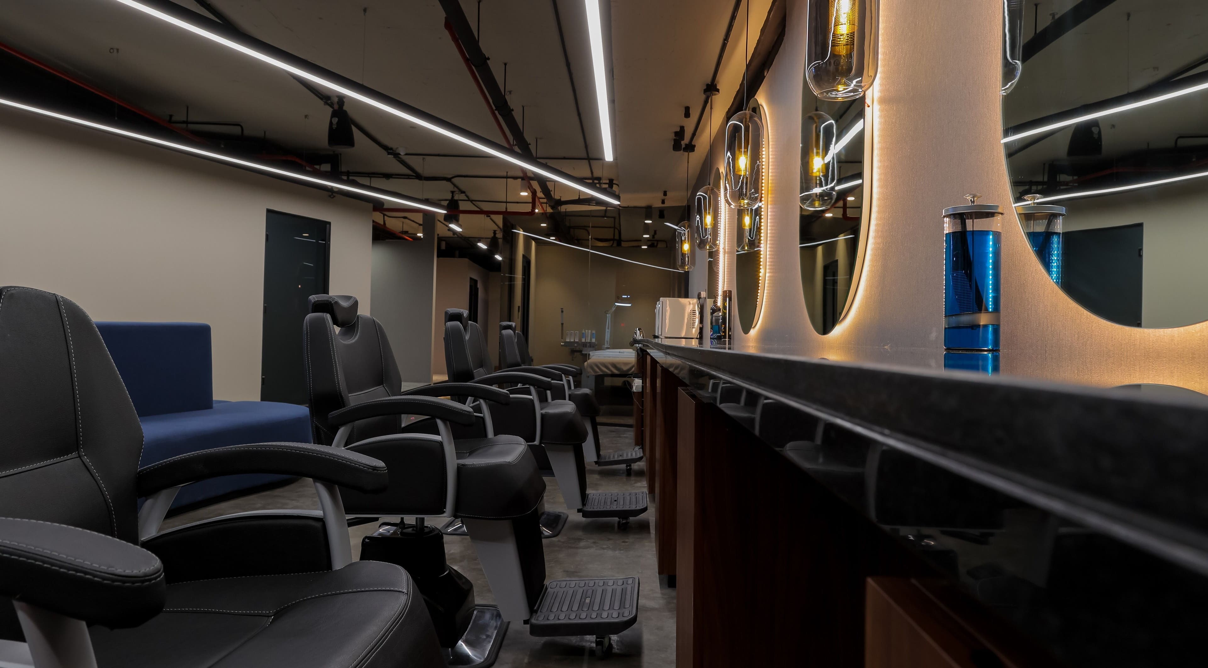 Chic salon interior at Hairpage, Saar BH with modern styling chairs and ambient lighting.