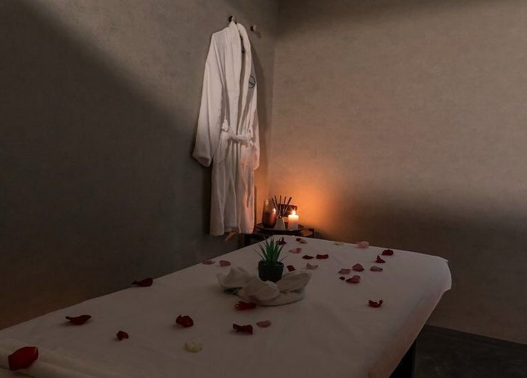 Relaxing spa room at Hairpage, Saar, BH with massage table, robe, and warm lighting.