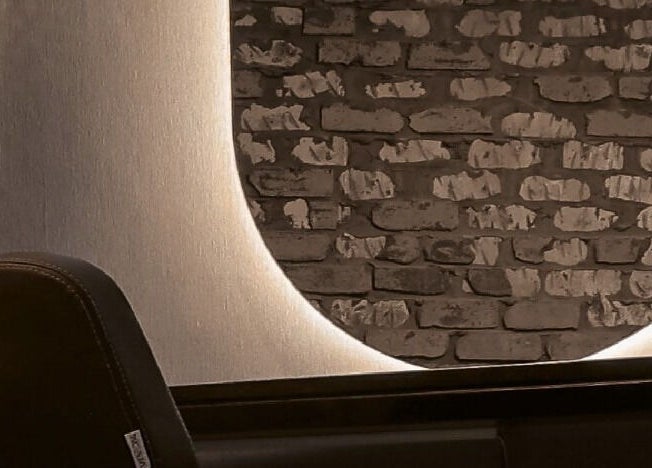 Stylish wall decor featuring rustic brick design at Hairpage in Saar, BH, enhancing salon's modern appeal.