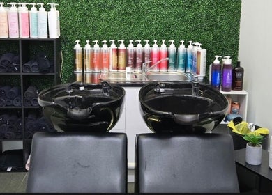 Shampoo station at Create Hair & Co in Corrimal, New South Wales, AU, featuring elegant black bowls and vibrant product display.