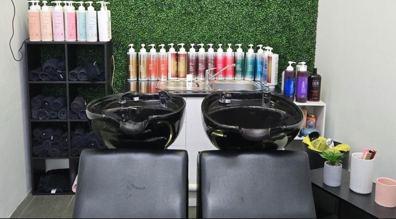 Shampoo station at Create Hair & Co in Corrimal, New South Wales, AU, featuring elegant black bowls and vibrant product display.