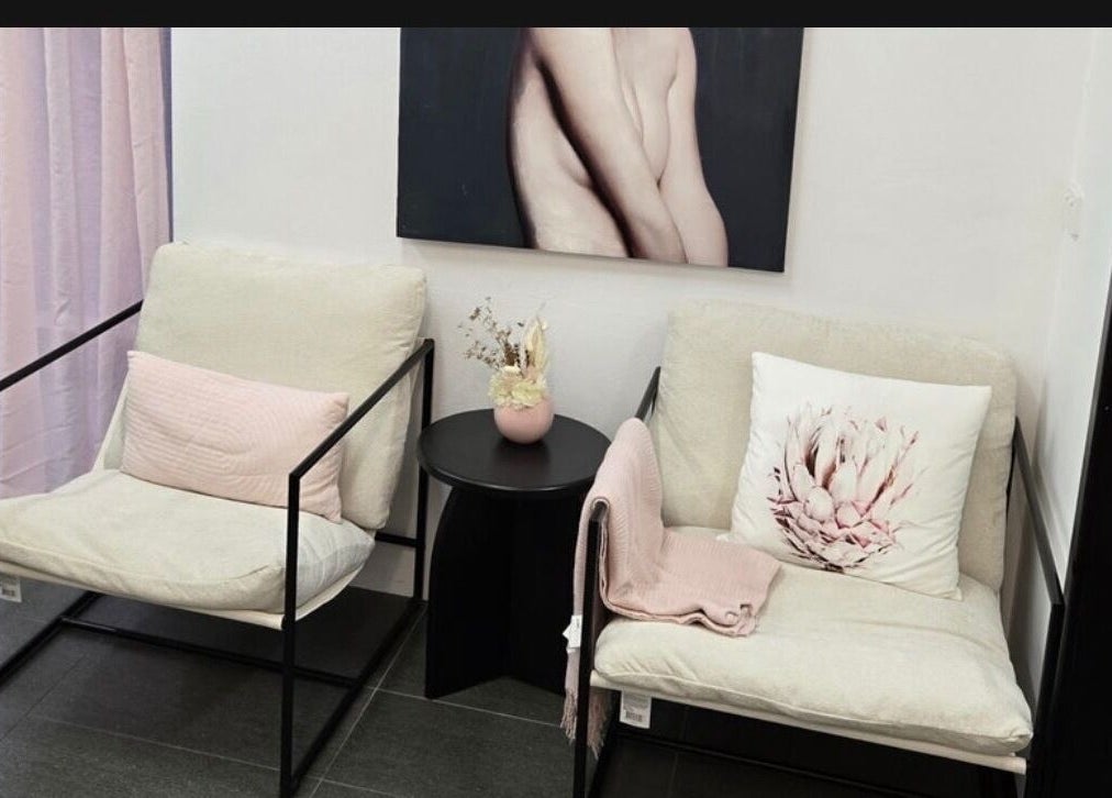 Elegant seating area at Create Hair & Co, Corrimal, New South Wales, AU, featuring pastel decor and a modern art piece.