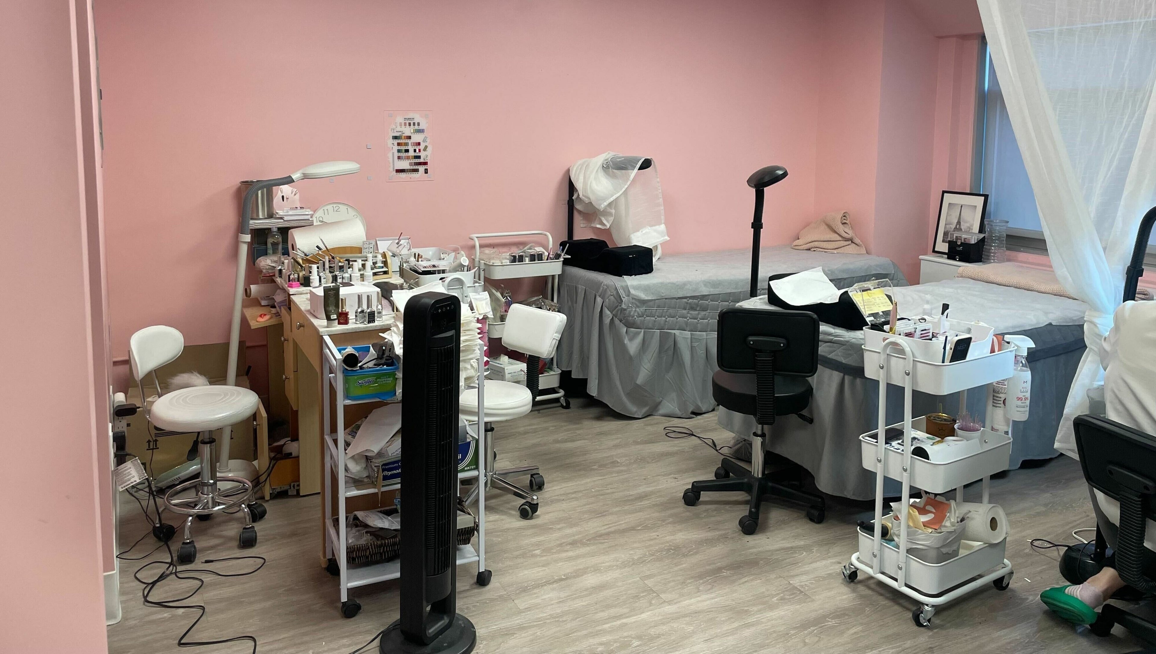 Inside Lash Moment Studio at Manhattan, New York, US, featuring a stylish treatment room with pink walls and comfy chairs.