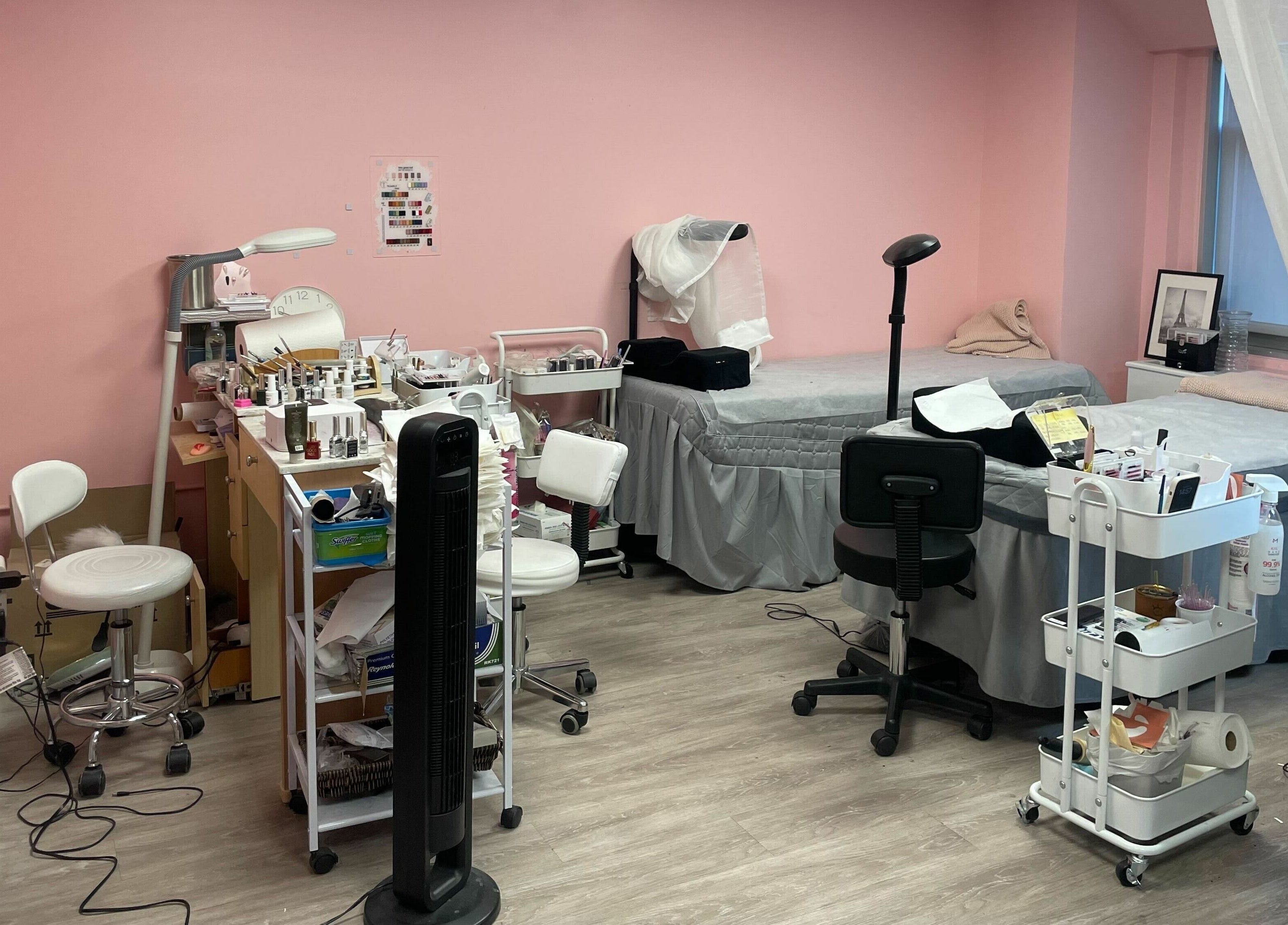 Inside Lash Moment Studio at Manhattan, New York, US, featuring a stylish treatment room with pink walls and comfy chairs.
