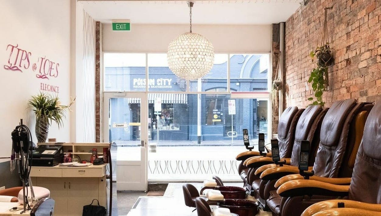 Relaxing lounge area at Tips and Toes - Fitzroy in Melbourne, Victoria, AU with massage chairs and chic decor.
