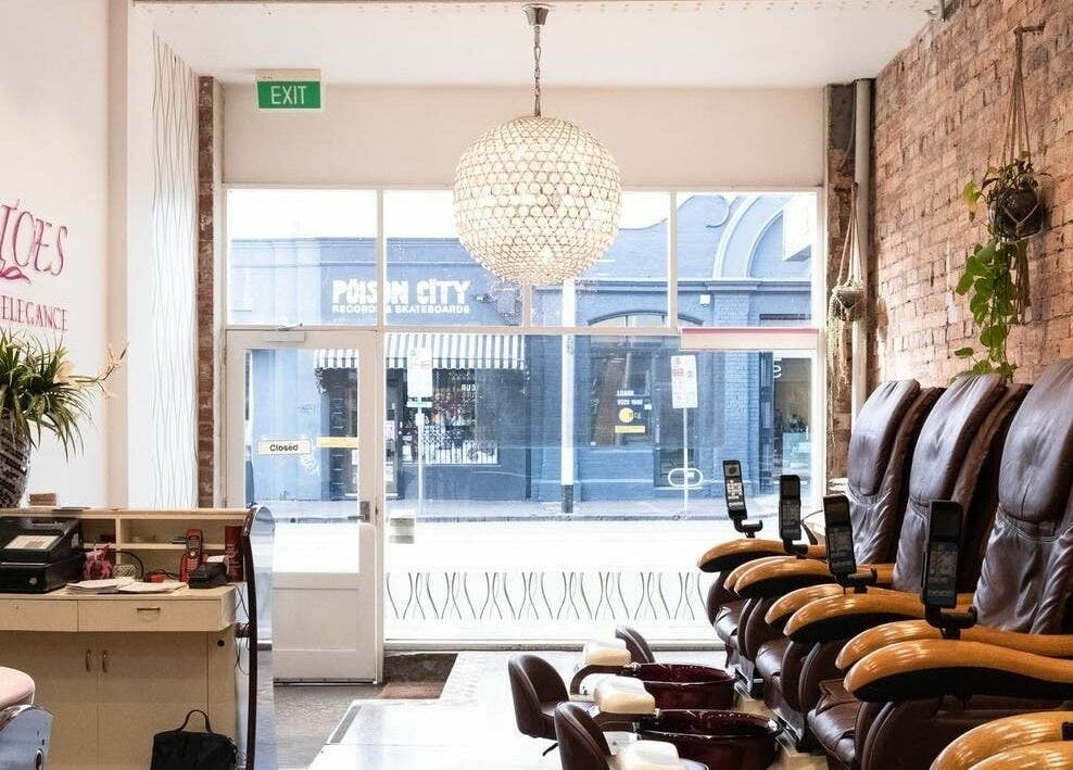 Relaxing lounge area at Tips and Toes - Fitzroy in Melbourne, Victoria, AU with massage chairs and chic decor.