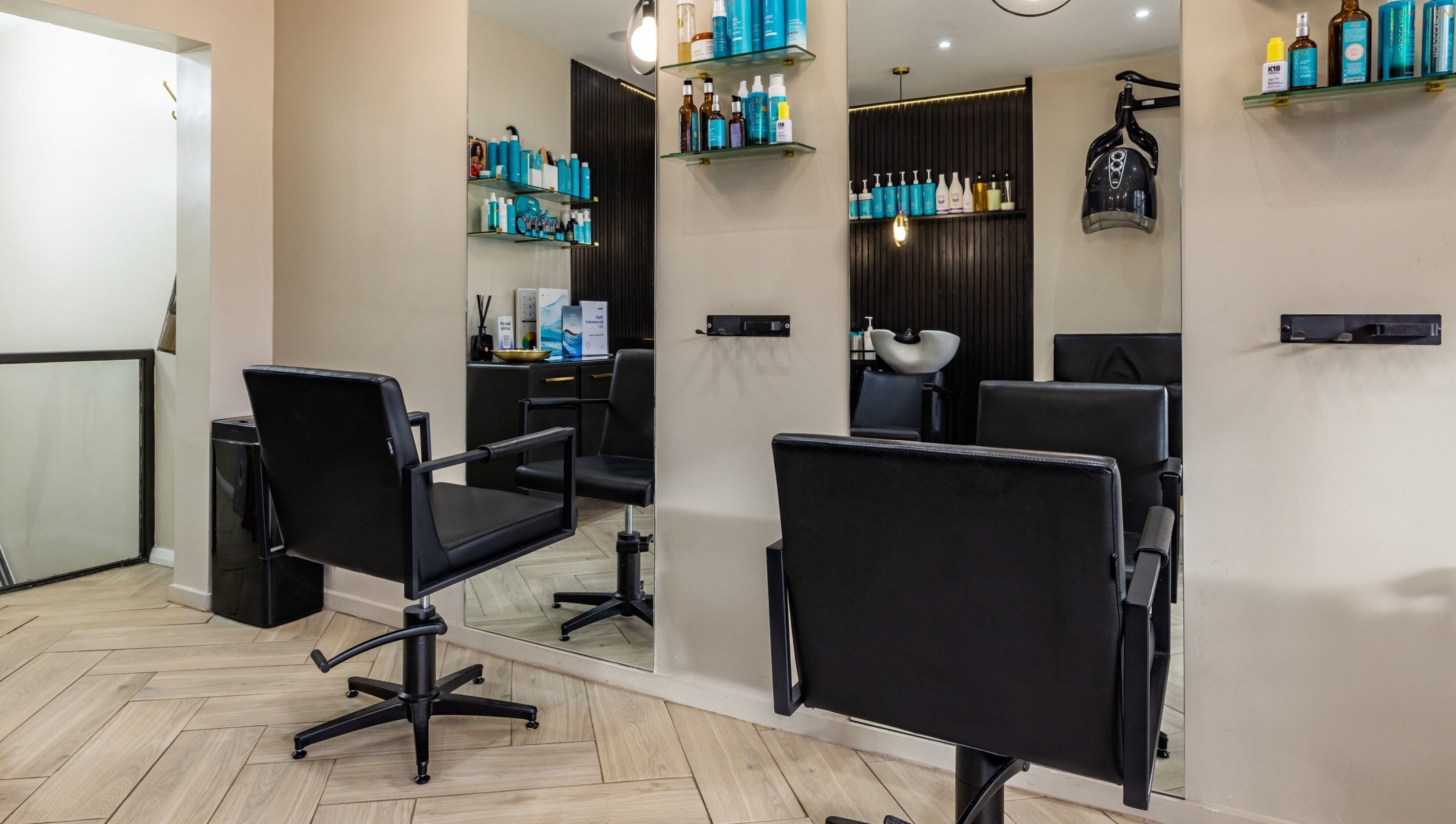 Interior of ATH Studios in Croydon, England, showcasing modern salon chairs and sleek product shelves.
