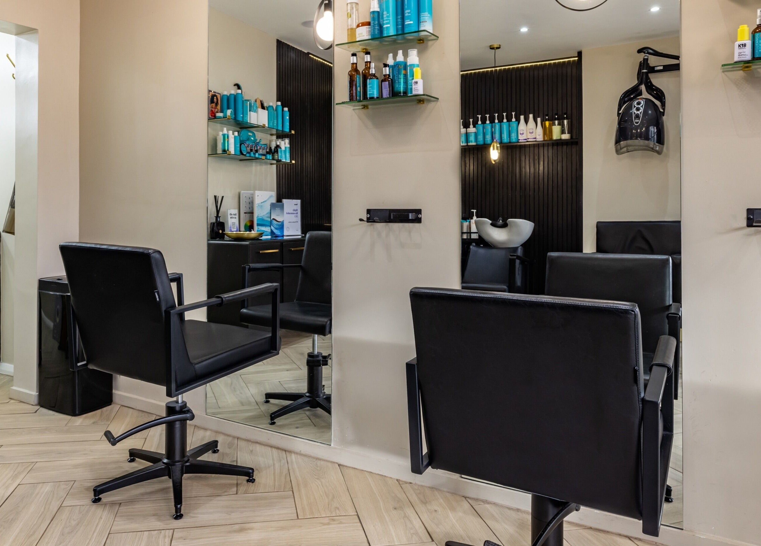Interior of ATH Studios in Croydon, England, showcasing modern salon chairs and sleek product shelves.