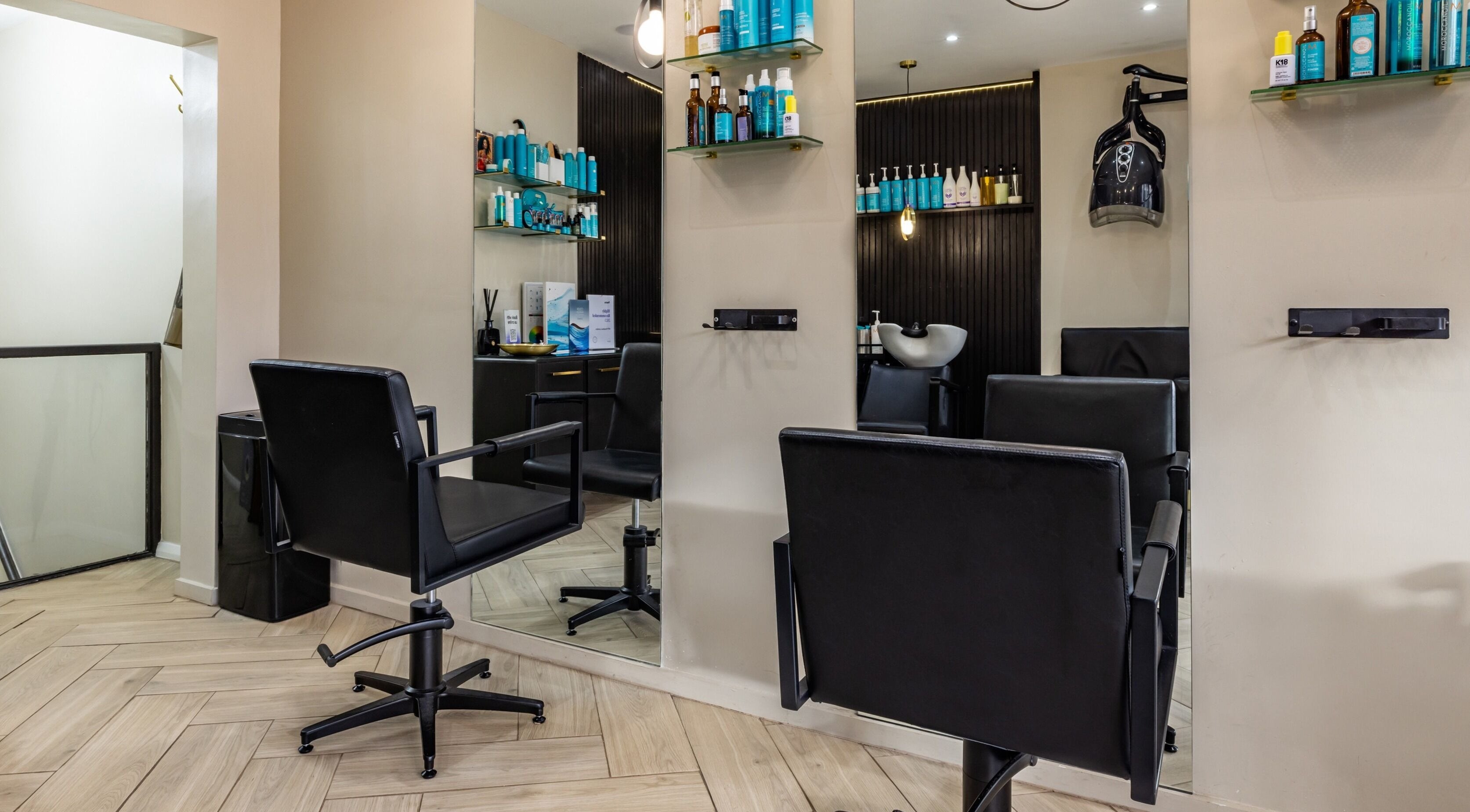 Interior of ATH Studios in Croydon, England, showcasing modern salon chairs and sleek product shelves.
