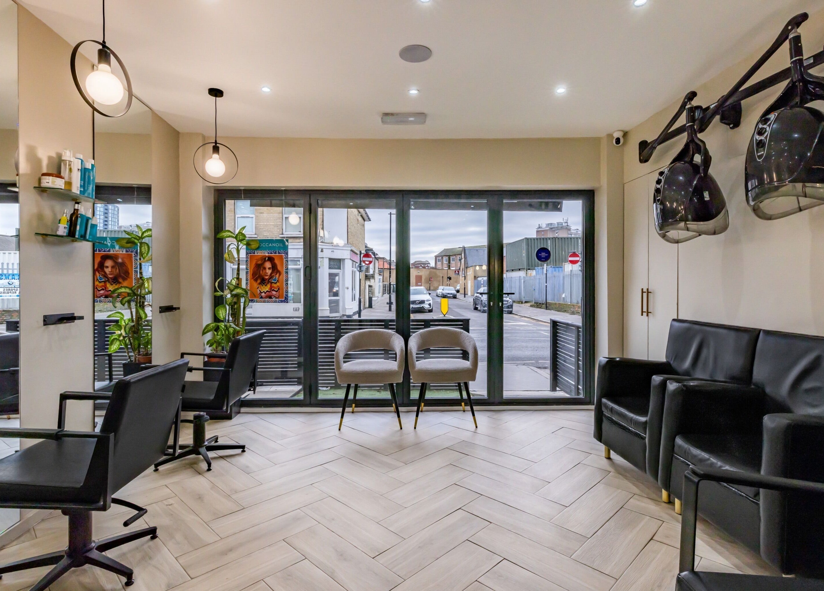 Modern salon interior at ATH Studios, Croydon, England, GB with sleek chairs and hairdryers.