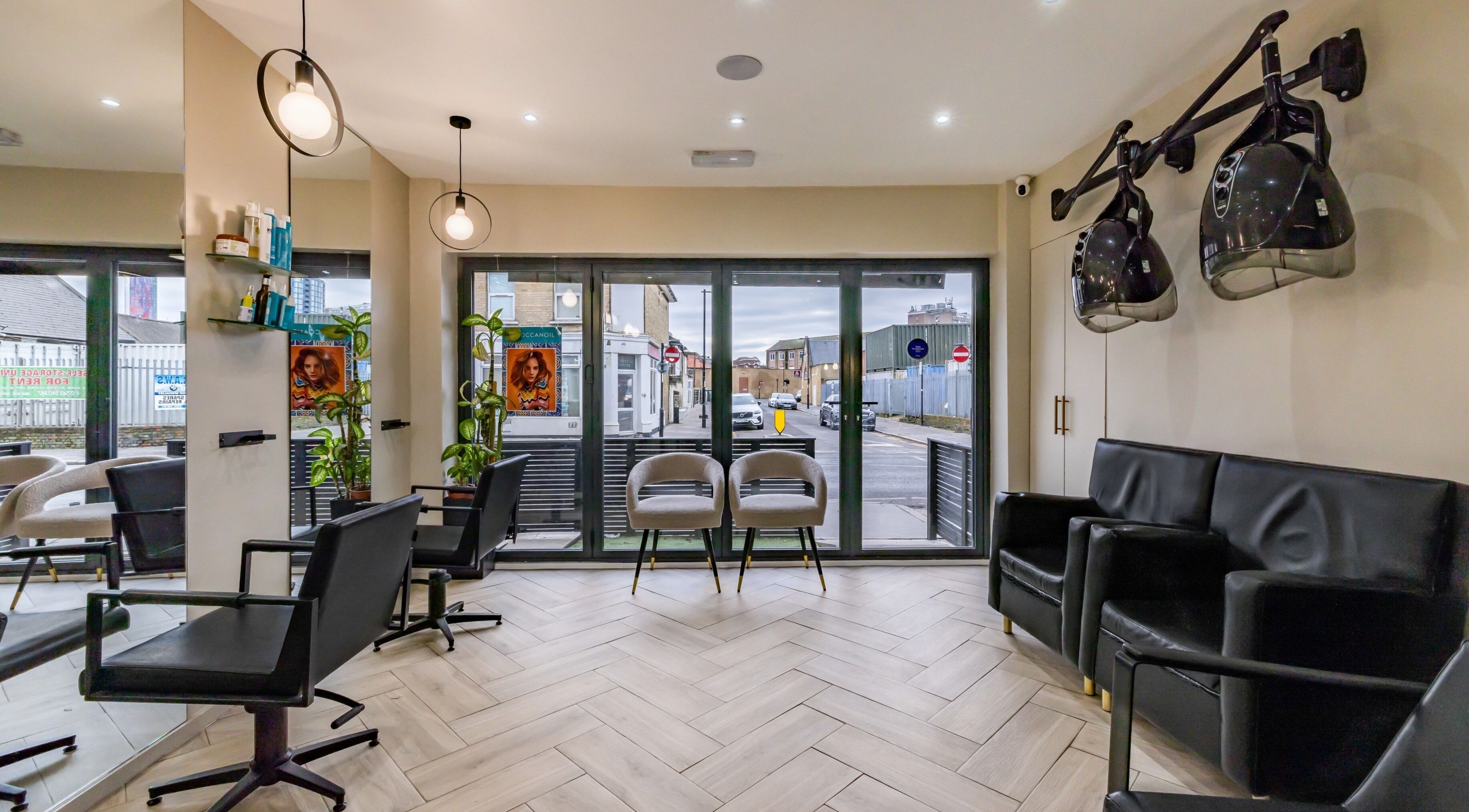 Modern salon interior at ATH Studios, Croydon, England, GB with sleek chairs and hairdryers.