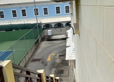 View from OM Wellness Spa, Bridgetown, Saint Michael, BB showcasing a tennis court and quaint alleyway.