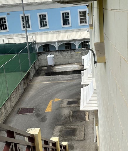 View from OM Wellness Spa, Bridgetown, Saint Michael, BB showcasing a tennis court and quaint alleyway.