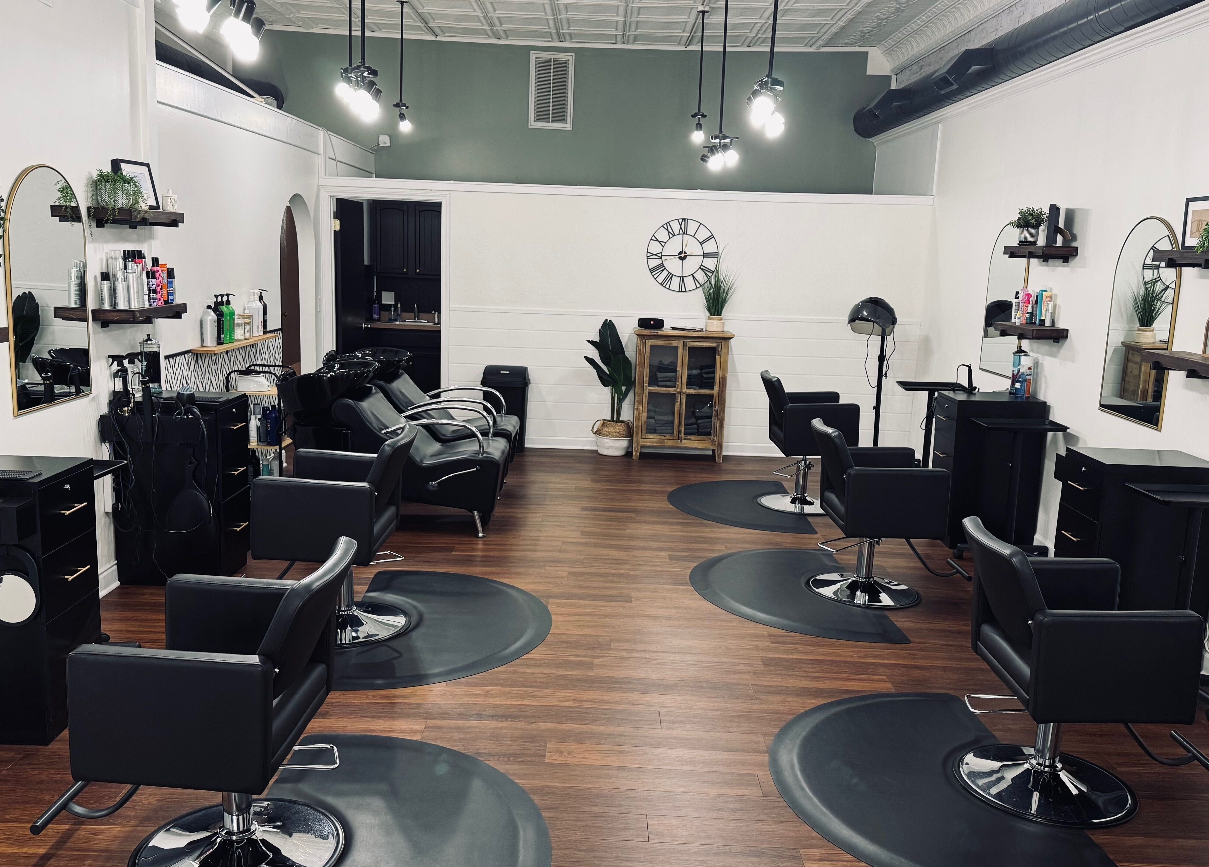 Modern interior of Rooted Salon in Eaton Rapids, Michigan, US, showcasing sleek black styling chairs and mirrors.