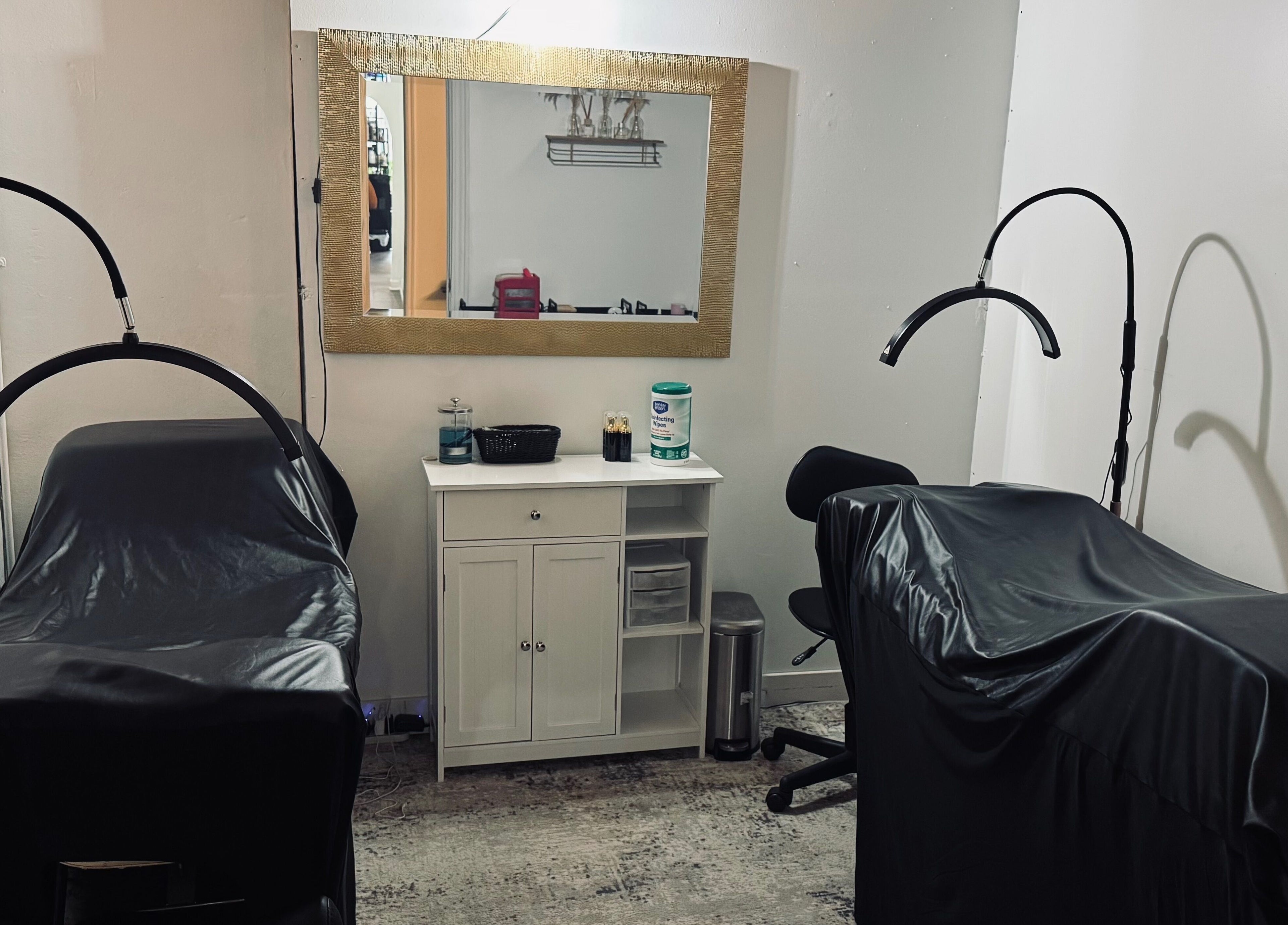 Cozy treatment spaces at Rooted Salon, Eaton Rapids, Michigan, US featuring luxe, black-covered chairs.