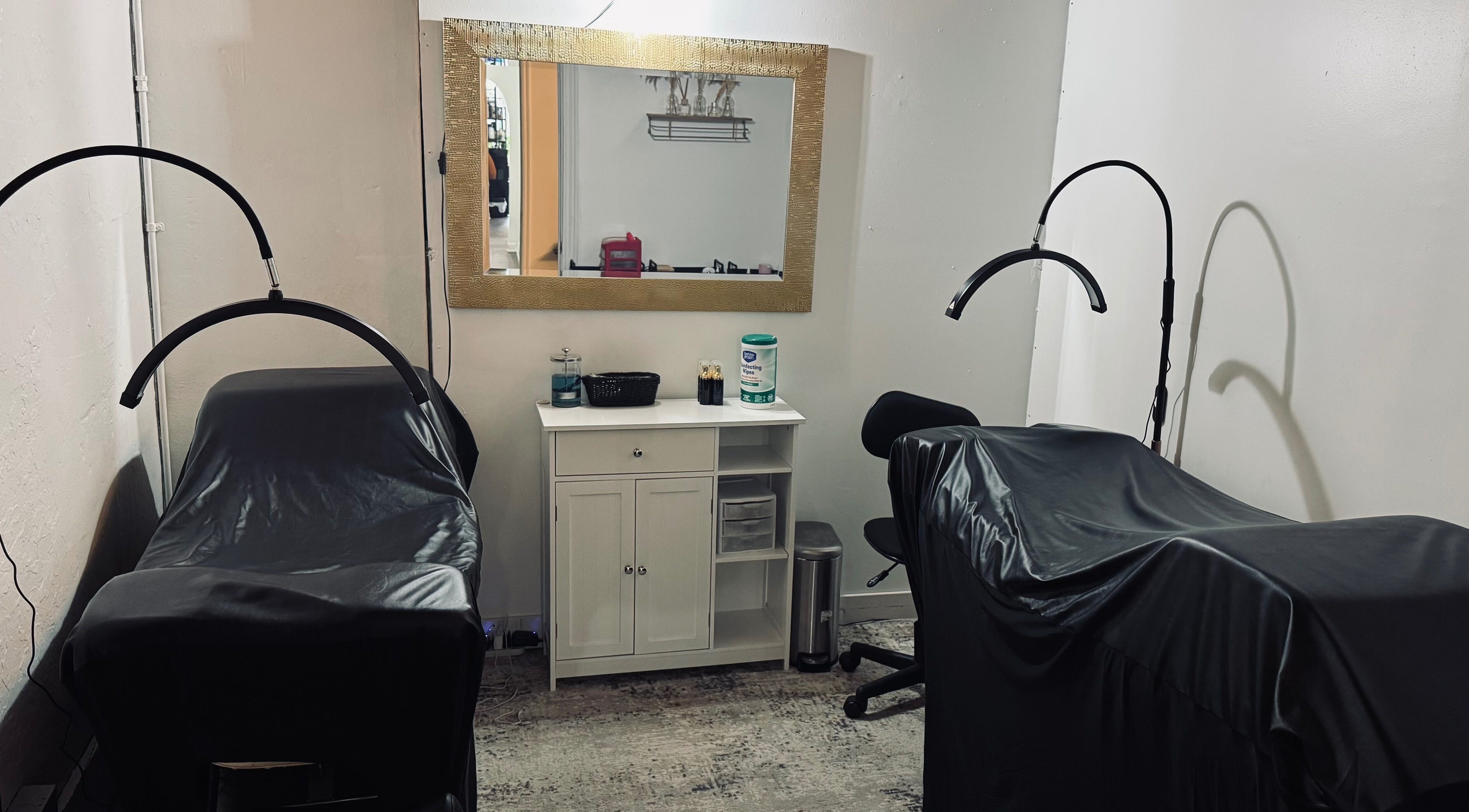 Cozy treatment spaces at Rooted Salon, Eaton Rapids, Michigan, US featuring luxe, black-covered chairs.