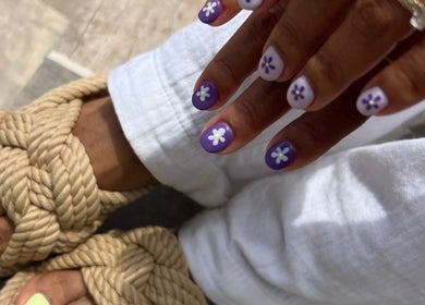 Floral nail art at QWN Esther Beauty Bar, Willemstad, Curaçao, CW with purple nails and braided sandals.