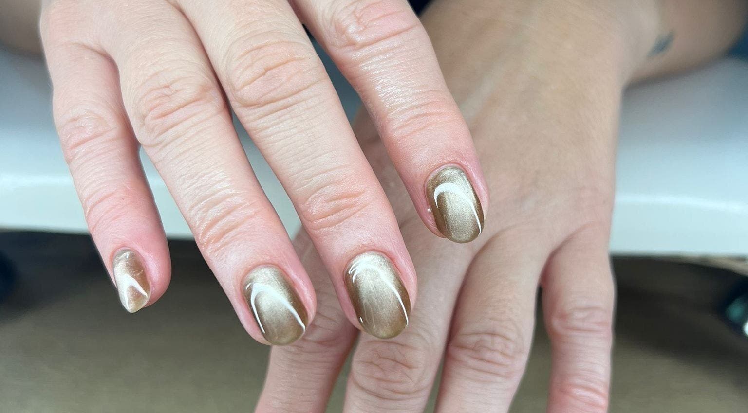 Elegant gold manicure at QWN Esther Beauty Bar in Willemstad, Curaçao, CW, showcasing exquisite nail artistry.