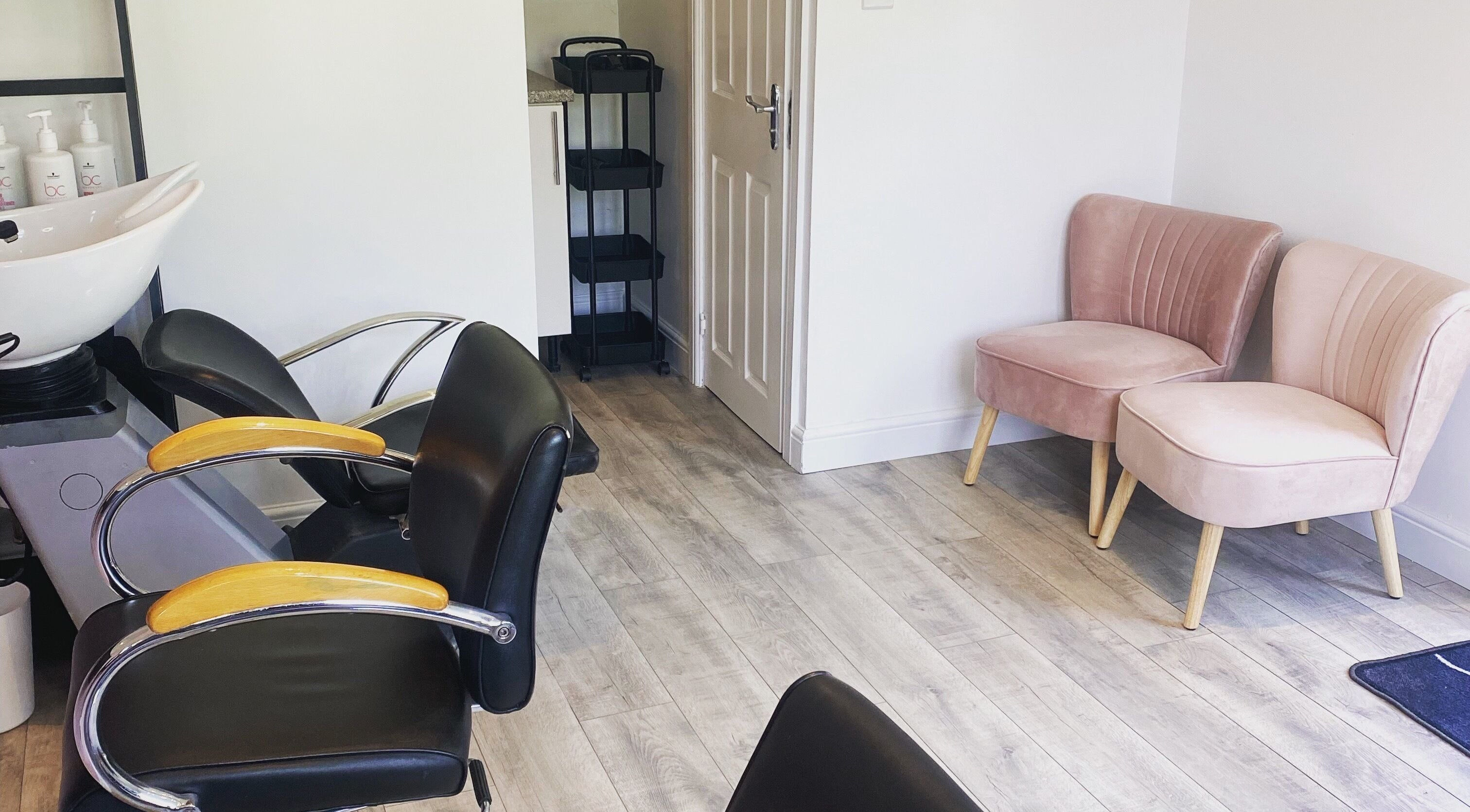 Modern seating area at The Salon at No.3 in Gloucester, England, GB with chairs and hair wash station.