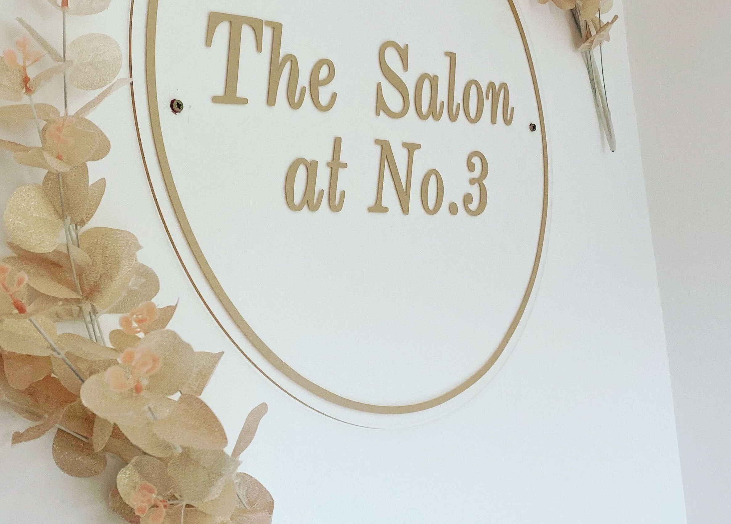 Elegant wall sign for The Salon at No.3 in Gloucester, England, GB, adorned with decorative floral accents.