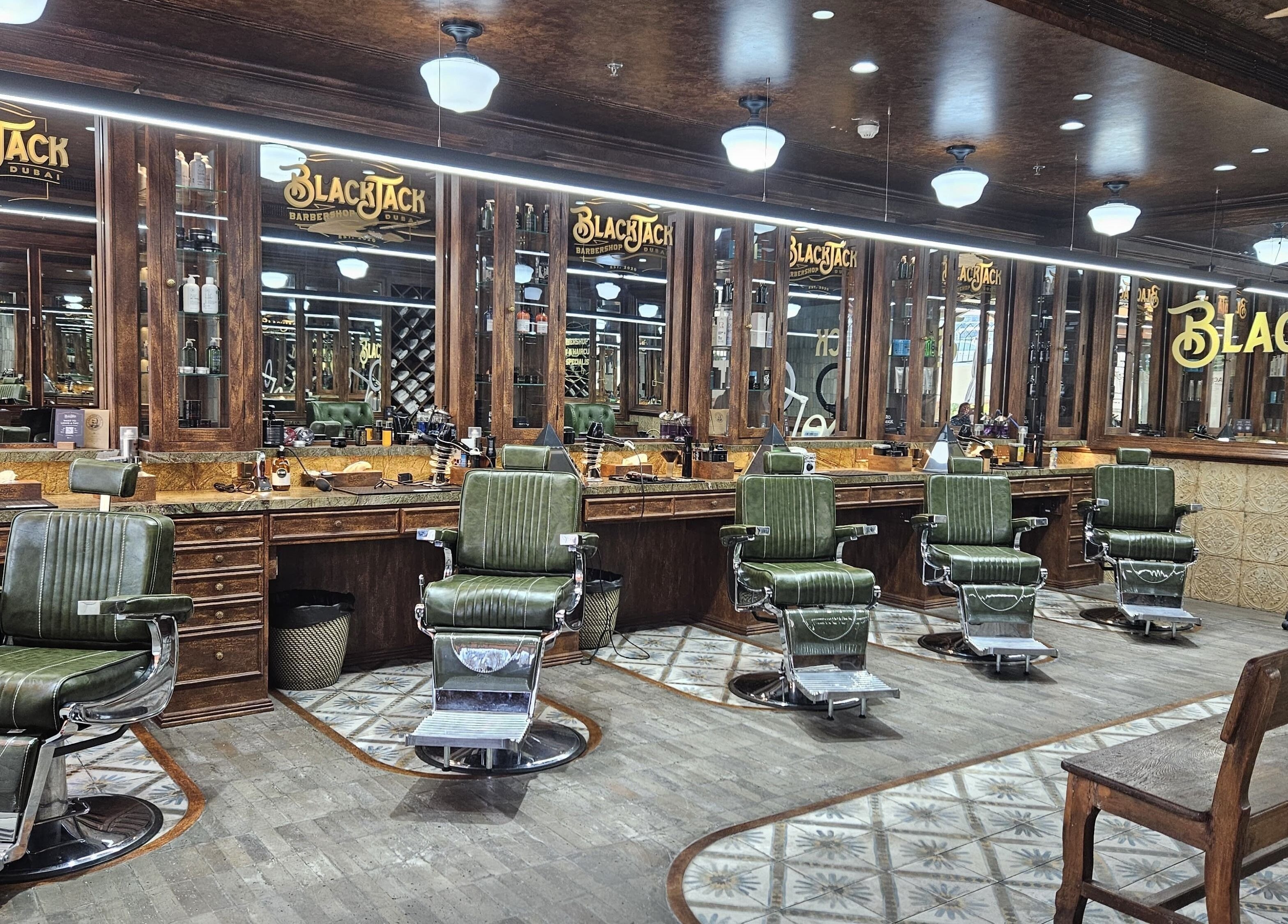 Interior of JBR BlackJack Barbershop, Dubai, featuring elegant vintage barber chairs and mirrors.