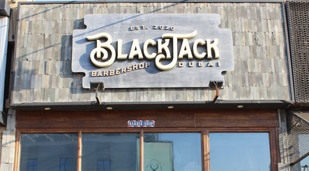 Exterior of JUMEIRAH 3 BLACK JACK BARBER SHOP, Dubai, Dubai, AE with rustic signage and wooden doors.