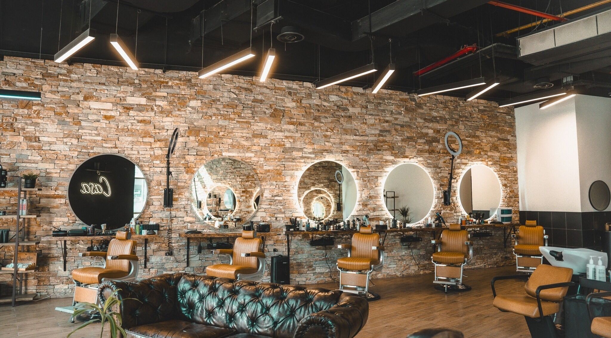 Elegant interior of Casa Barbershop, Dubai, AE, featuring chic barber chairs and modern lighting.
