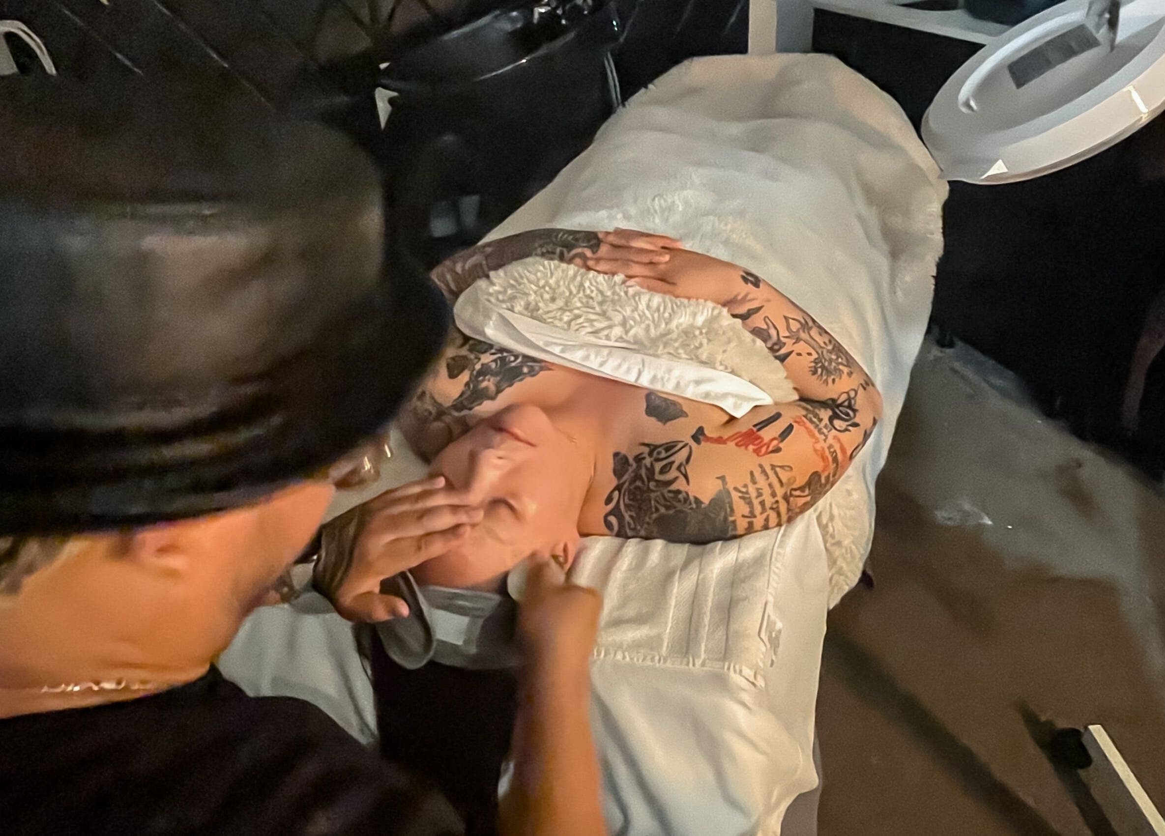 Client enjoying facial massage at Skin and Scissors Beauty Studio in Orange, California, US.