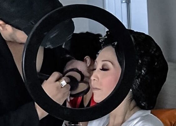 Makeup artist applying makeup at Skin and Scissors Beauty Studio, Orange, California, US.